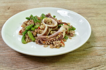 spicy fried chili squid with chop pork and basil leaf couple slice yard long bean on plate