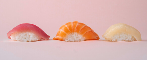 Salmon, tuna and perch sushi set on pink background © Andrey