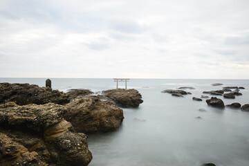 Fototapeta na wymiar rocks and sea with torii gate