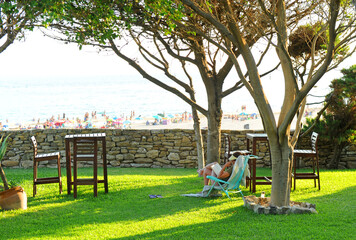 Obraz premium Woman reading quietly in the garden of a beach house at sunset, Tarifa beaches. Costa de la Luz Cadiz Spain