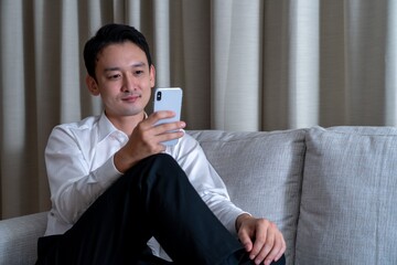 携帯を操作するアジア人男性