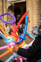 Multi colored sword shaped balloons for sale in Bologna downtown, Italy, during the carnival.