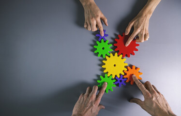 business development, teamwork and collaboration concept - people connecting gears. top view copy space