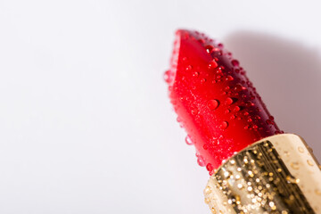 close up view of red wet lipstick on white background