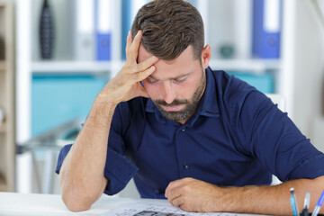 stressed man in office looking on documents