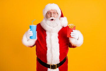Fototapeta na wymiar Portrait of his he nice cheerful stunned amazed funny white-haired Santa eating fastfood menu recipe meal dish sale discount isolated over bright vivid shine vibrant yellow color background