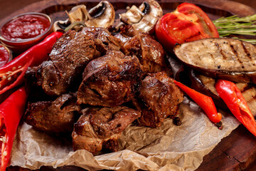 Lamb roasted over charcoal with sauce and spices on a wooden board.