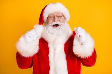 Photo of delighted santa claus raise fists enjoy x-mas newyear holly magic miracle lottery win raise fists wear red cap headwear isolated over bright shine color background
