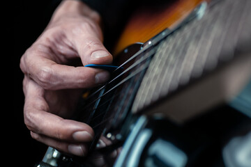Guitarist hands and guitar strings close up.