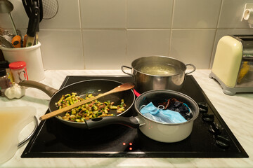 Typical view of a lockdown evening in Europe. Food cooking while masks are boilling in the kitchen.