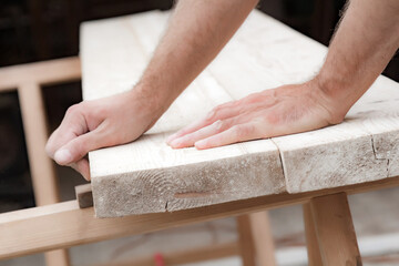 Male carpenter working with wood material in a garage.