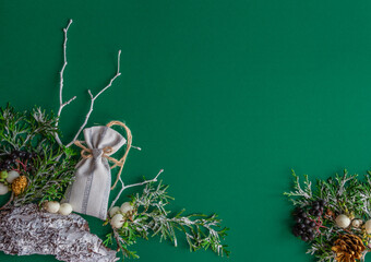 Christmas, New Year card - fir branches, gift bag on a green background, stylish. Flat lay, copy space, top view
