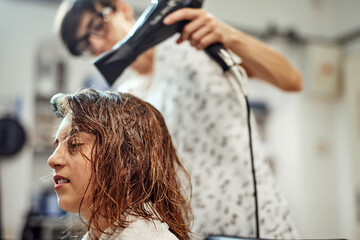 Fototapeta premium Hairdresser cutting hair in a salon.