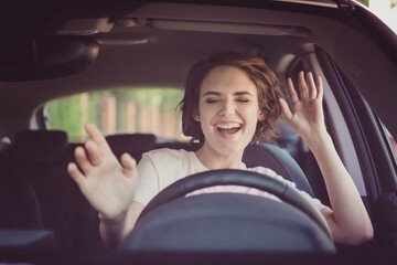 Photo of positive cheerful girl funky driver rider enjoy drive ride car under pop star hits...
