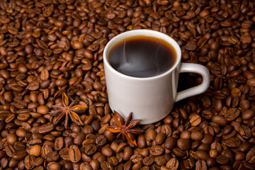 A cup of coffee on the background of coffee beans.