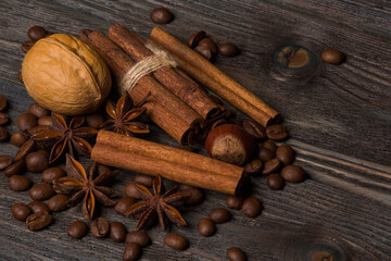 Cinnamon, anise stars, walnut, coffee grains on wooden background.