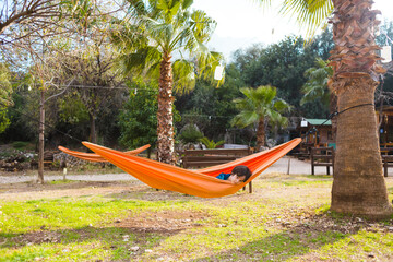 Fototapeta premium The boy lies in a hammock.