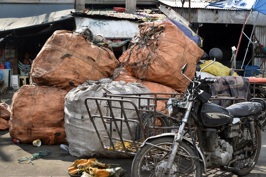 Huge sacks of recyclable materials being hauled by motor tricycle into the city junk yard