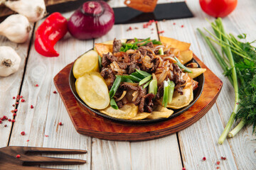 Fried potatoes with beef in cast iron pan
