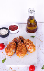 Delicious homemade crispy fried chicken with sauces on white marble background