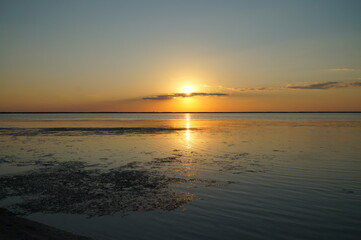 A sunny path from the setting sun on the calm water of the estuary.   
