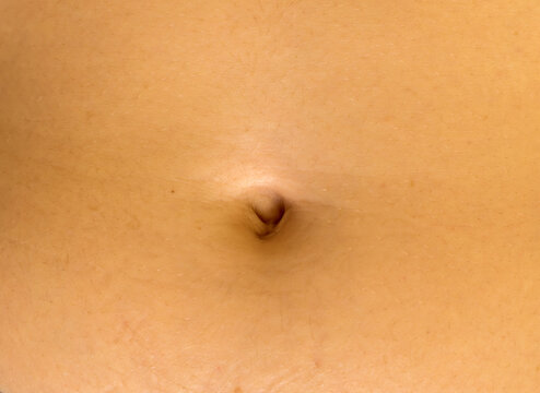 The close-up view of a navel of unrecognizable young caucasian female.