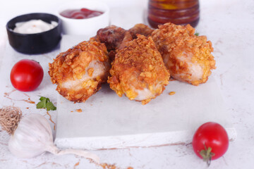 Delicious homemade crispy fried chicken with sauces on white marble background