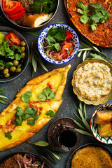 Traditional Turkish food, assorted dishes and mezze appetizers on rustic background from above. Pide, Lahmacun, meat kebab, Turkish meatballs, sweet baklava and Künefe. Middle East cuisine, top view