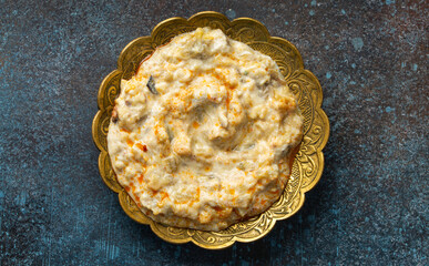 Baba Ganoush - traditional Turkish meze of yoghurt and roasted aubergine, Middle Eastern appetizer or dip in plate on rustic background. Top view