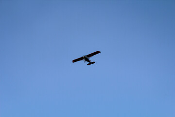 Ein Kleinfluzeug mit Propellerantrieb am Himmel.