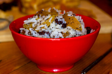 handmade preparation of treats for traditional Orthodox Christmas - rice pudding with fruits, cranberries, honey, nuts, Church candles