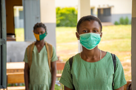 Two School Kids Wearing Face Masks And Physically Distancing Themselves