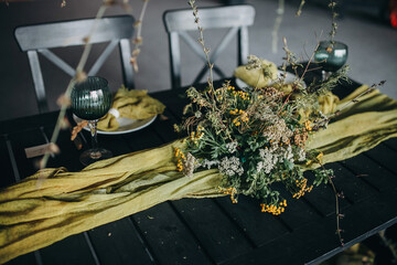 Banquet table with a glass of painted napkins and natural flowers