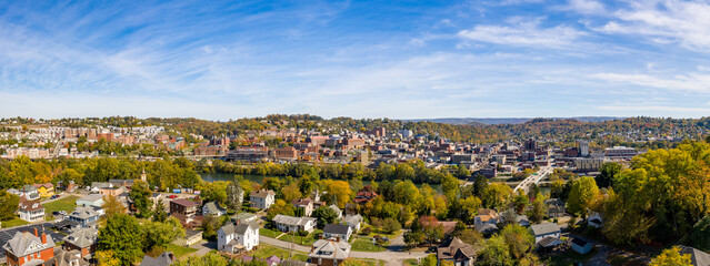 Obraz premium Aerial drone panoramic shot of the downtown area of Morgantown with the WVU campus in the fall