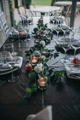 Candles and natural flowers in the decoration of the banquet table