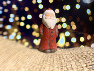 Christmas decoration, Santa Claus figurine, with bokeh effect background with a thorny green plant...