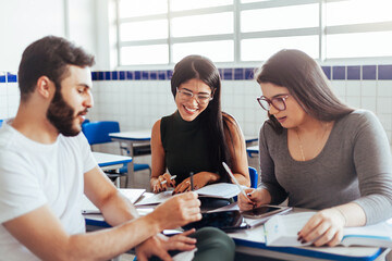 Multiethnic group of college students talking in classroom.