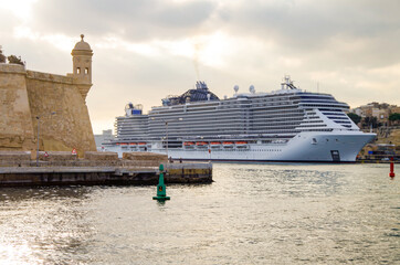 Mega modern MSC cruiseship or cruise ship liner in port of Valletta, Malta island with panoramic...