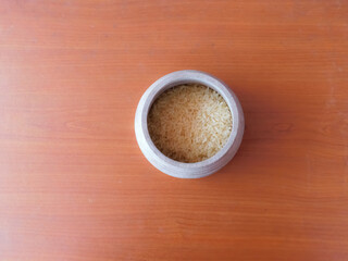 closeup of rice's in a bowl isolated on wooden surface