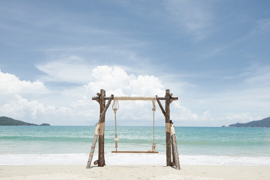 View of nice wooden swing on summer tropic beach