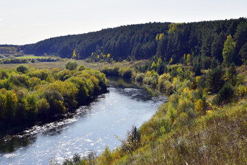 Bend of the Iren river near a high and rocky bank. Sunny autumn in the foothills of the Western Urals.