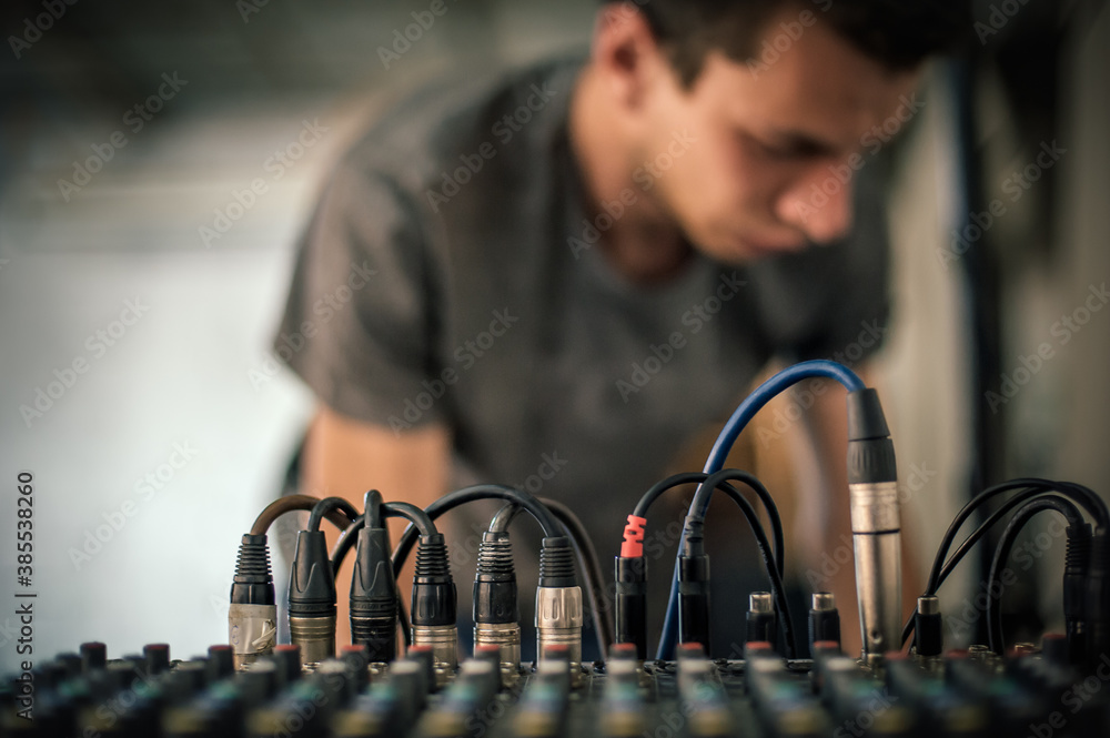 Wall mural Behind the scene. Sound technician electric engineer adjusting sound elements backstage. Control audio panel. Audio mixing console