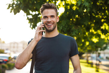 Smiling attractive young man talking on mobile phone