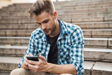 Handsome young man using mobile phone