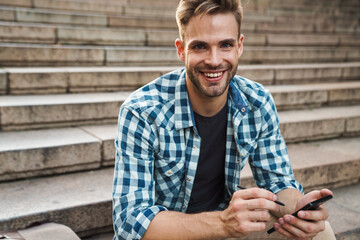 Obraz premium Handsome young man using mobile phone