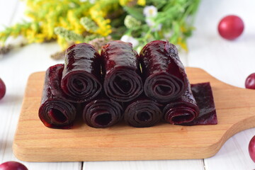 Fruit pastille from plums on a white table. Close up