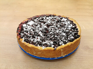 Delicious homemade pie with blueberries and cherries on a wooden table. Home baking concept for website, postcard, banner.