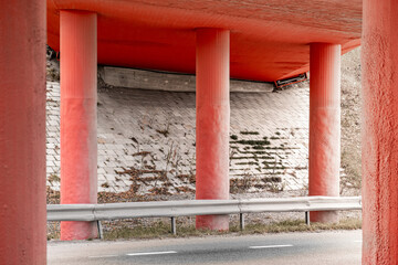 Fototapeta na wymiar Under a red bridge with a road