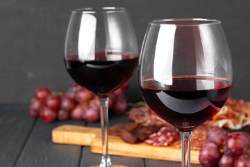 Wineglass with red wine and meat cuts board