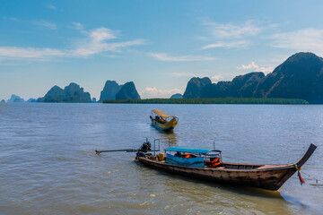 Fototapeta na wymiar Longtailed speed boats moored off the settlement and island of Ko Panyi in Phang Nga Bay, Thailand